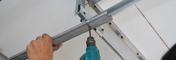 Person befestigt Metallprofil an Decke